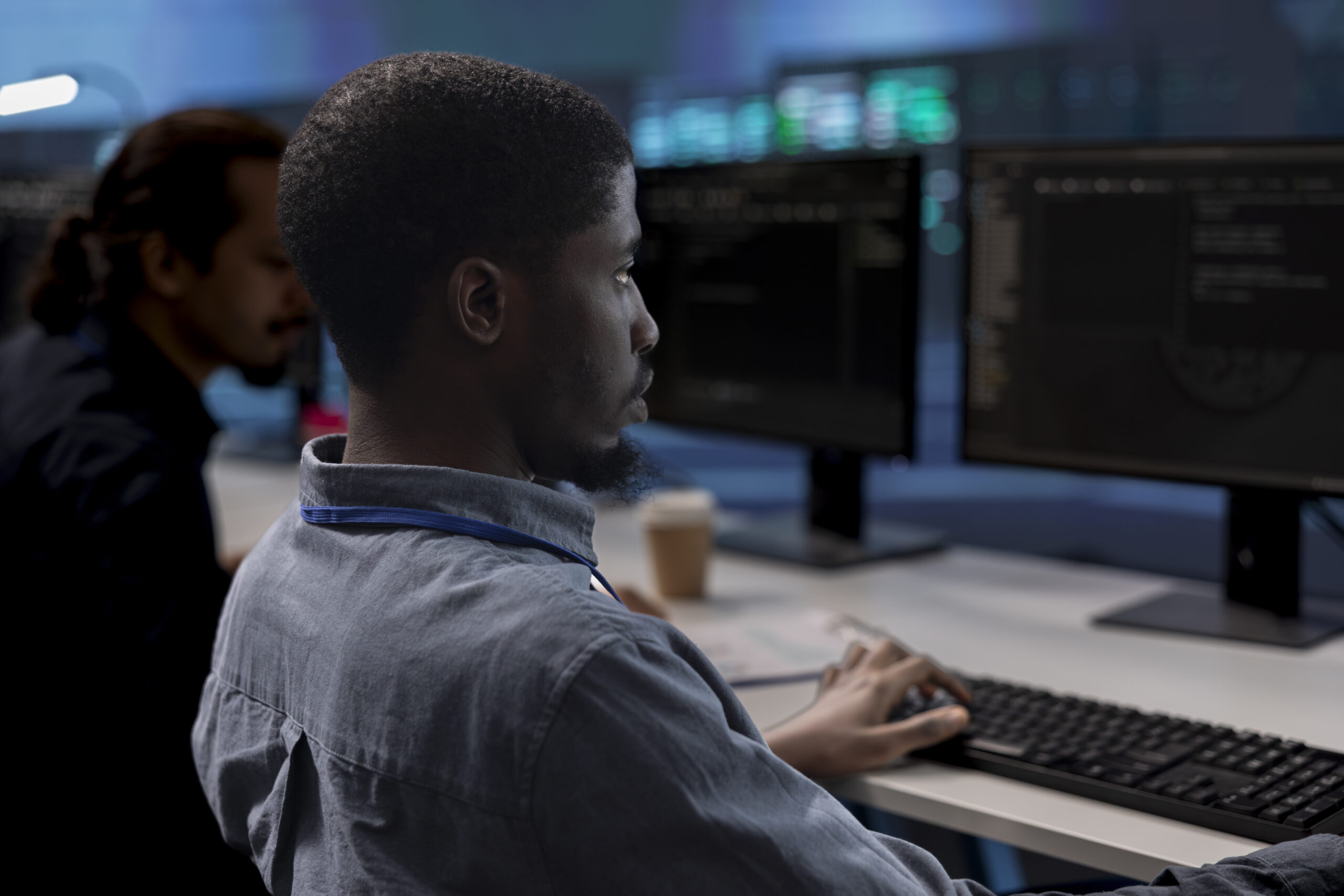 Computer scientists checking for signs of imminent failure in data center equipment. Employees working at PC desks to preventing server clusters damages, monitoring critical systems